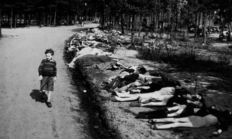 A young survivor walks along a road lined by the corpses of hundreds of prisoners who died at the Bergen-Belsen camp, in May 1945. 