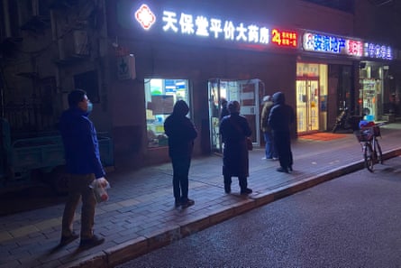 People wait in queue to buy medicine at a pharmacy amid the Covid-19 pandemic in Beijing
