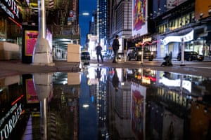 The lights of Times Square are reflected in a puddle as Storm Ida left behind not just water on city streets but wind damage and severe flooding along the eastern seaboard