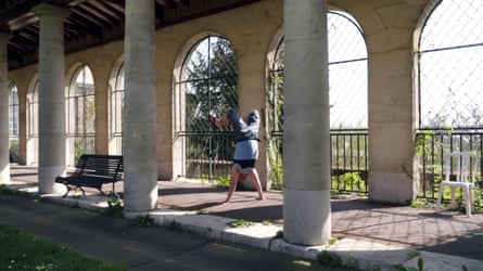 film still of a columned courtyard with a person doing a handstand