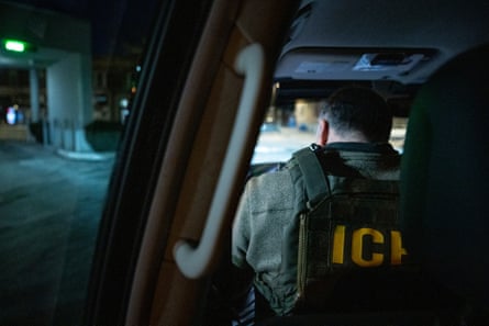 a man wearing an Ice vest sits in a car