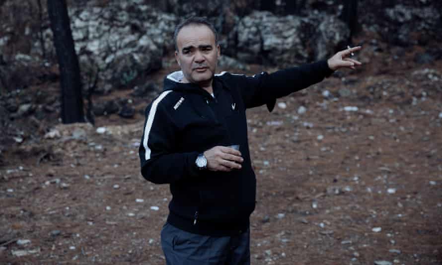 Muhammet Sahin, 50, points to areas of fire damage outside his cafe and restaurant in the village of Osmaniye.