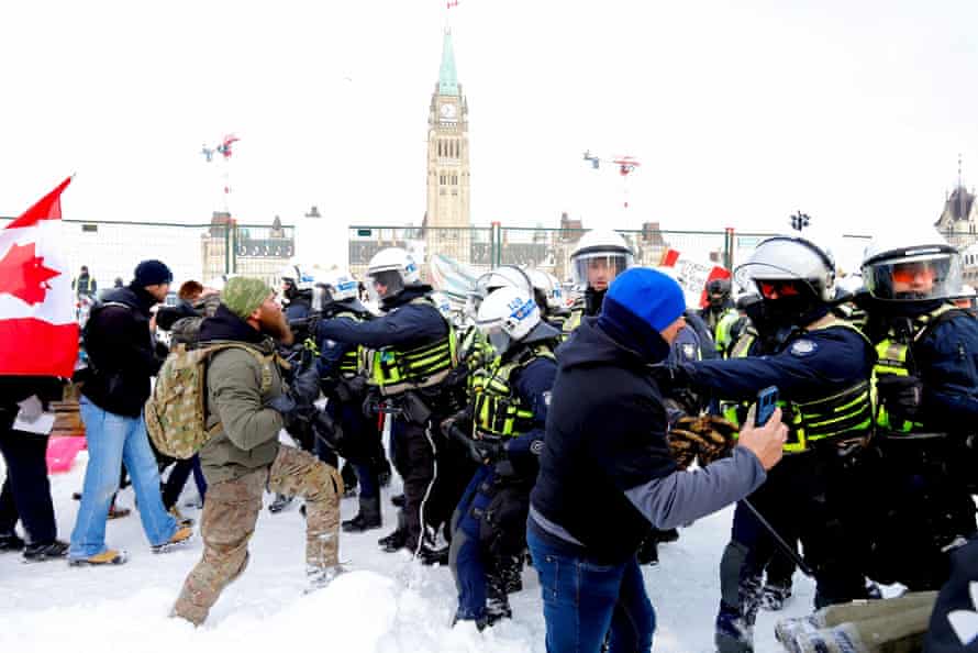 Canadian police advance on protesters in front of Parliament Hill.