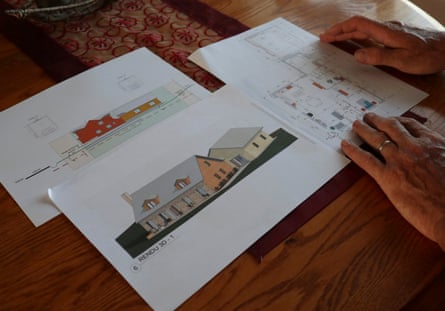 A man’s hand on top of the plan and elevation for a single-storey house