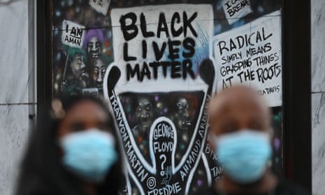 Two people watch on during a demonstration in Black Lives Matter Plaza in Washington DC in November 2020.