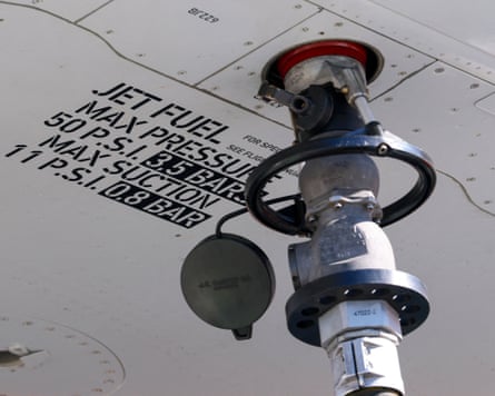 A nozzle attached under the wing of an aircraft during refuelling with jet fuel.