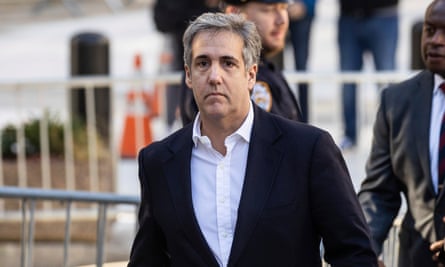 Middle-aged white man with long features and gray hair, in dark suit jacket and white shirt, no tie, walks beyond police barriers.
