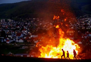 Luegde, GermanyPeople walk past a fire while celebrating f the traditional ‘Osterraederlauf’.