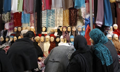 Women look at veils on display at an exhibition hall for the Muslim World Fair in Le Bourget, outside Paris