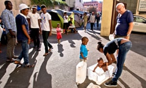 An Eritrean mother in Rome tries to bathe her daughter in the city’s migrant camp.