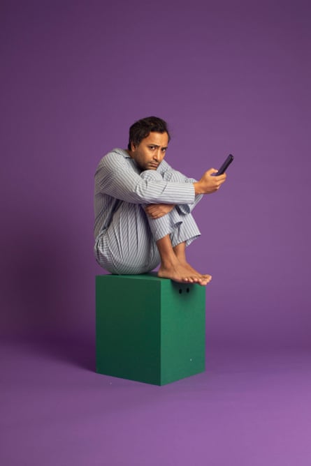 Rhik in his pyjamas sitting on a green block against a purple background