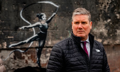 Labour Party leader Keir Starmer stands in front of an art piece by British artist Banksy on a wall of a residential building at the Irpinsky Lipky residential complex which was heavily damaged during fighting between Russian and Ukrainian troops in the town of Irpin.