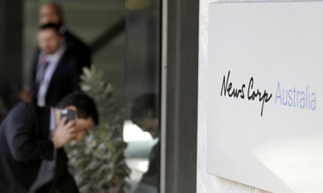 A man speaks on a phone at the entrance to the News Corp headquarters in Sydney