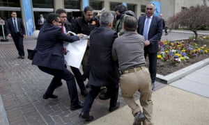 Turkish security struggle to take a sign away from protesters in front of the Brookings Institute.