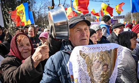 A Moldovan demonstrator bangs a spoon on a dish next to another holding a religious icon during a protest on behalf of the Sor opposition party in Chisinau in March last year