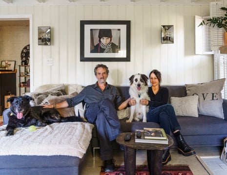Man and woman sit with two dogs on an L-shaped couch