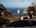 Paddy Maddison cycles downhill on a coastal mountain road above the sea