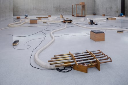 Pipes and wires create a sound installation on the floor of a gallery