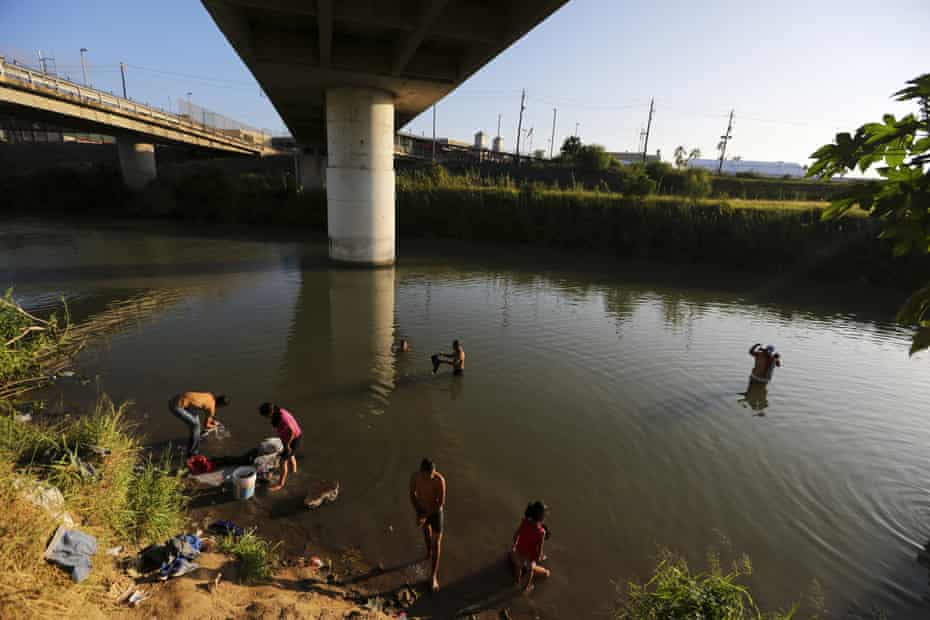 Migrants wash their clothes in the Rio Grande in Matamoros, Mexico, across the border from Brownsville, Texas. 