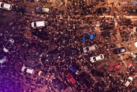 Bird's-eye view of people swarming the streets alongside cars as the centre of Belgrade fills up with people celebrating the defeat of Aleksandar Vučić