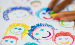 Child’s drawing of happy smiling faces with colouring pencils.