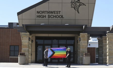 Former Viking Saga newspaper staff members Marcus Pennell, left, and Emma Smith, right, display a pride flag outside of Northwest high school in Grand Island, Nebraska. 
