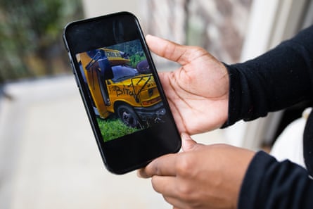 Hands holding phone with image of vandalized school bus