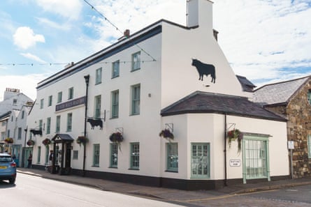 Large white pub with bull image on the outside wall. Ye Olde Bulls Head Inn on Castle Street in Beaumaris Anglesey