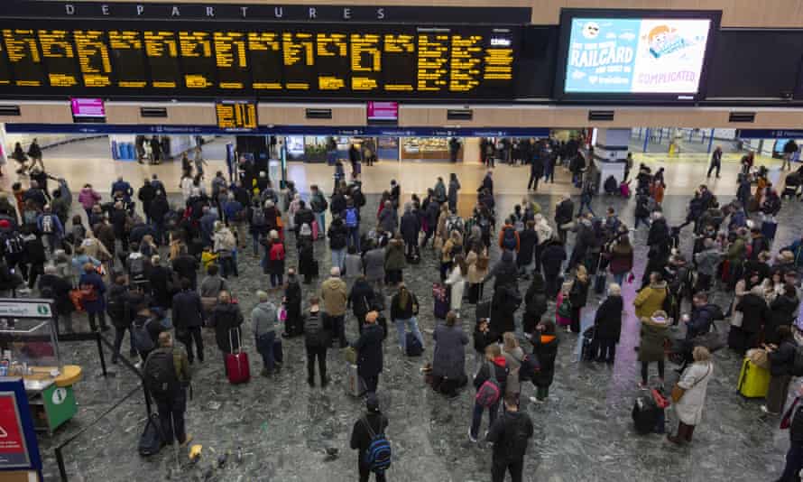 People wait in line at a London train station as a result of the cancellation of some services due to the storm.