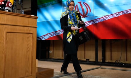 Hamideh Zarabadi walking away from podium with flag behind her
