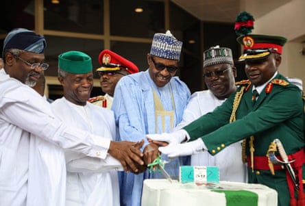 (From left) The speaker of the House of Representatives Femi Gbajabiamila, vice-president Yemi Osinbajo, president Muhammadu Buhari and senate president Ahmed Lawan get a bit of military assistance cutting an anniversary cake during a ceremony marking 60 years of independence from the UK, on 1 October 2019.