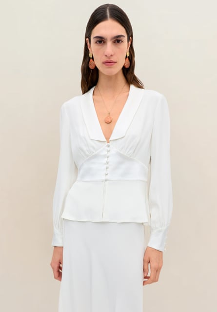 A woman in a white top and white long skirt.