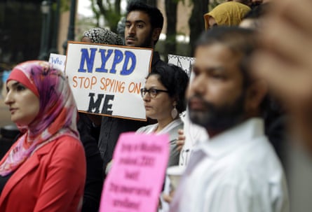 A man holds a sign that says ‘NYPD stop spying on me’ in a crowd