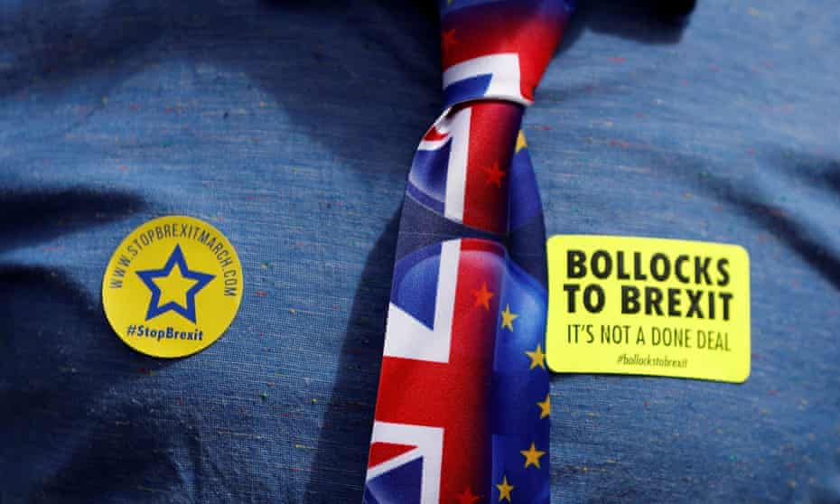 A demonstrator wears 'Bollocks to Brexit' stickers and an EU and union flag tie.