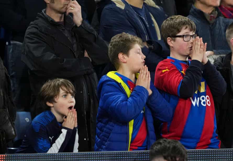 Young Crystal Palace fans pray before a penalty kick.