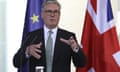 Starmer speaking against a backdrop of a Union flag and an EU flag