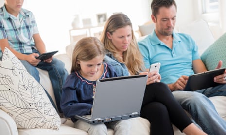 A family using phones, laptops and tablets at home