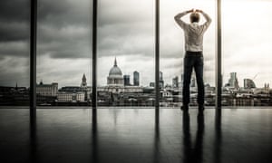 City trader with hands on head looking out over the city.