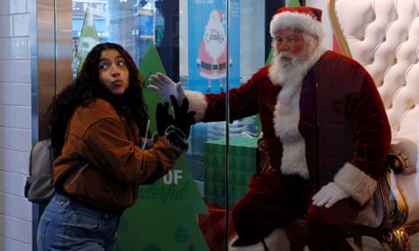 Santa Claus greets shoppers from behind a store display window in Boston. Many Americans are scrambling to make new plans in light on the new variant.
