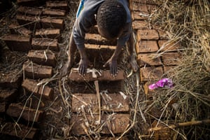 Ambrose, 11, who works at a brick-making site with his mother in Uganda. Child labour has risen steeply during the pandemic.