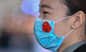 An airport worker wears a face mask with a sticker of the Chinese flag at Tianhe airport in Wuhan