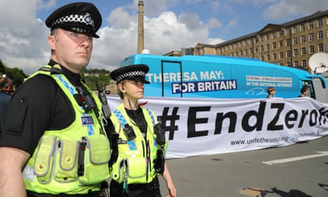 Police stand by as protesters unfurl a large banner against zero hours contracts in front of the Conservative Party ‘battle bus’ in Halifax in northern England