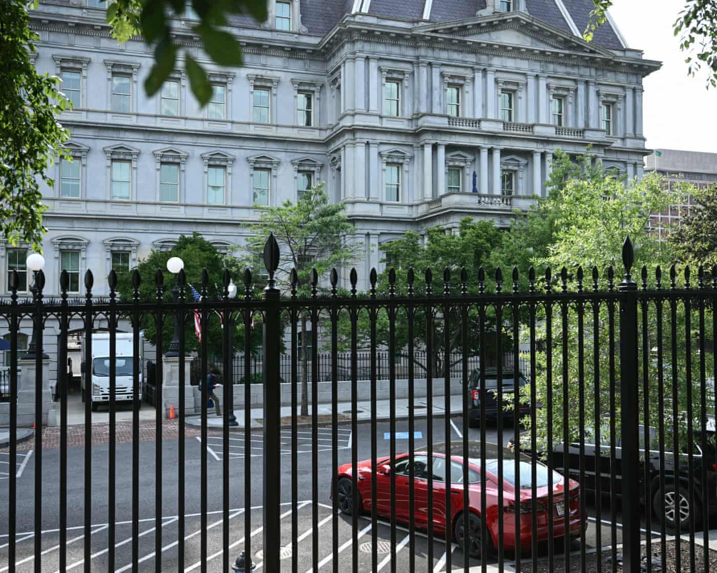 Trump Tesla: Musk Feud & Potential Sale – Live Updates A red Tesla parked outside the white House.