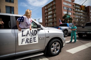 Healthcare workers stand in the street as a counter-protest to those demanding the stay-at-home order be lifted in Denver, Colorado, on 19 April.
