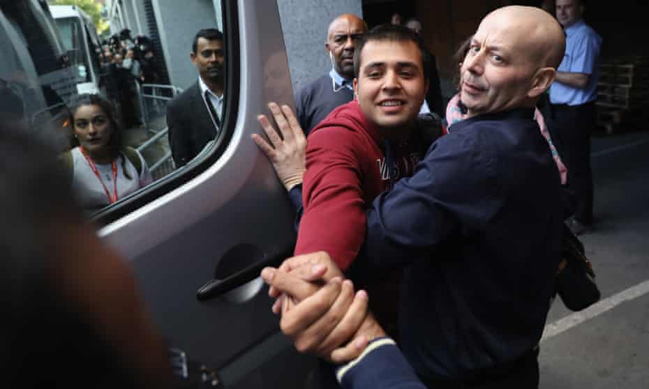 Jan Ghazi, (out of shot) greets his brother Haris who outside a Home Office processing centre in Croydon, south London.