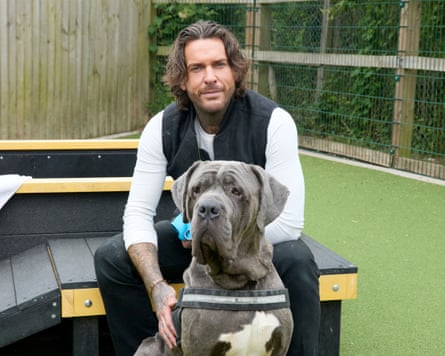 A man sitting with a large grey dog