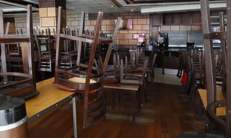 Chairs and tables stacked up in a deserted pub.