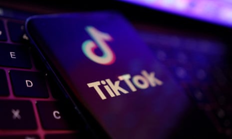 The TikTok logo on a smartphone screen on top of computer keyboard