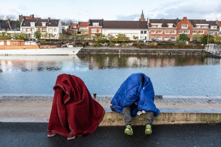 Badr e seu primo Mhamod, 20, cobrem-se com cobertores no centro de Calais.