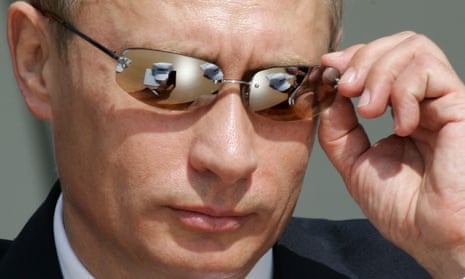 Russian president Vladimir Putin adjusts his sunglasses.